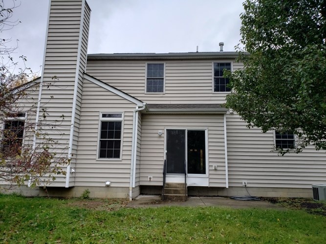 A house with a grey facade and a black door.