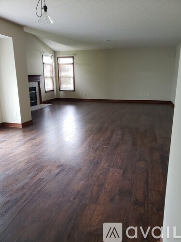 A room with wooden floors and a fireplace.