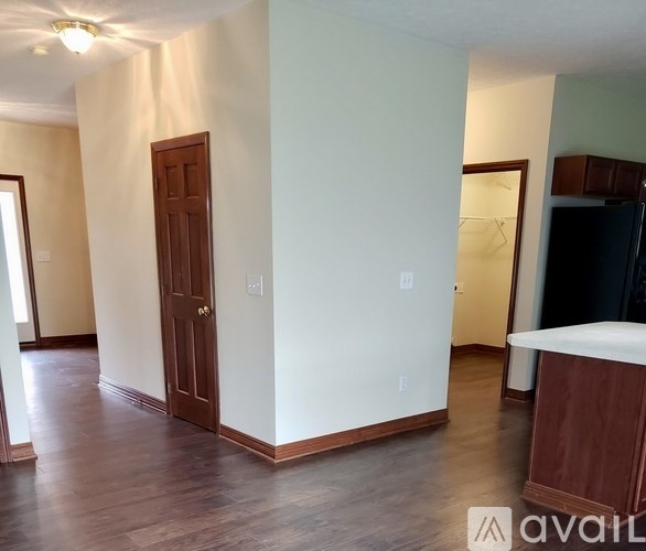 A room with a brown door and a white wall.