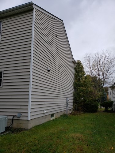 A house with a grey siding and a white trim.