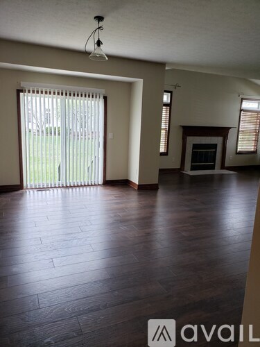 A room with wooden floors and a fireplace.