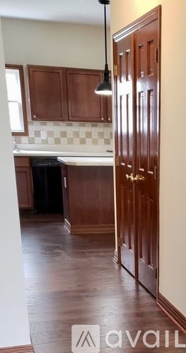A kitchen with wooden cabinets and a checkered backsplash.