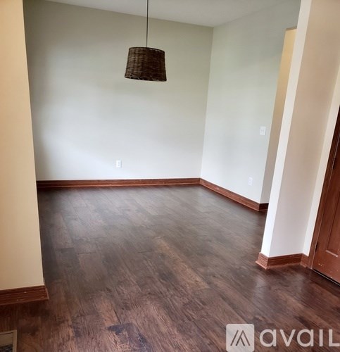 A room with wooden floors and a hanging light fixture.