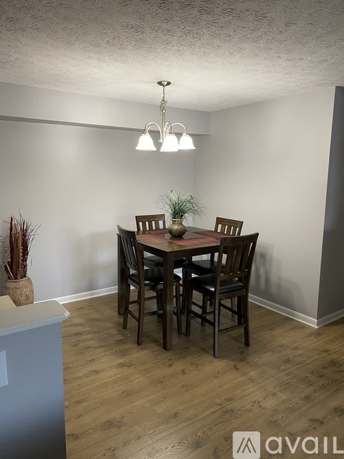 A dining room with a table and chairs.