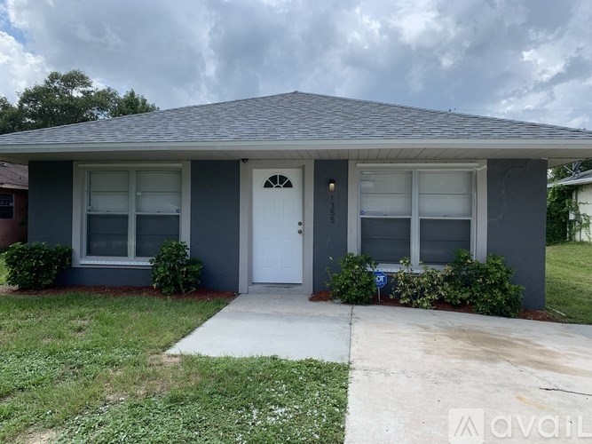 A house with a grey roof and a white door is for sale.