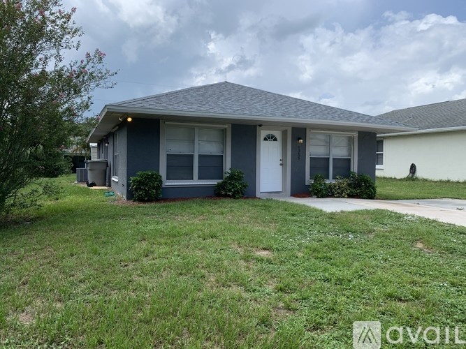 A house with a grey roof and a white door is for sale.