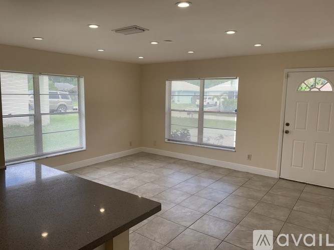 A spacious room with a black countertop and tiled floor.
