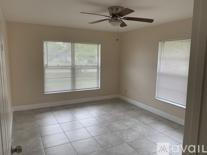 A room with a ceiling fan and tiled flooring.