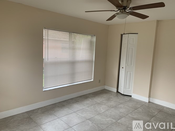 A room with a ceiling fan and a door.
