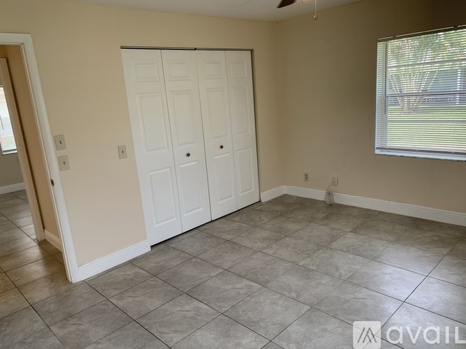 A room with a white door and tiled floor.