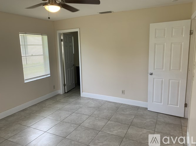 A room with a ceiling fan and tile flooring.