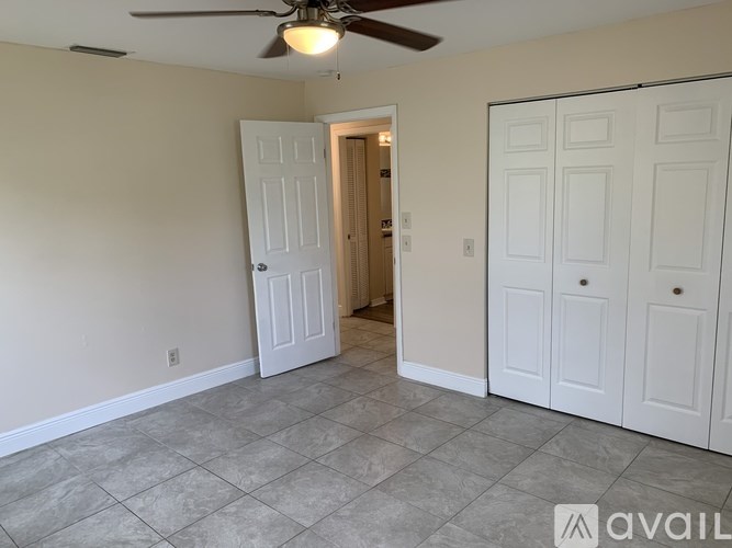 A room with a ceiling fan and two doors.