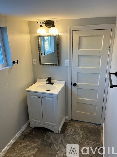 A bathroom with a white sink and a white door.