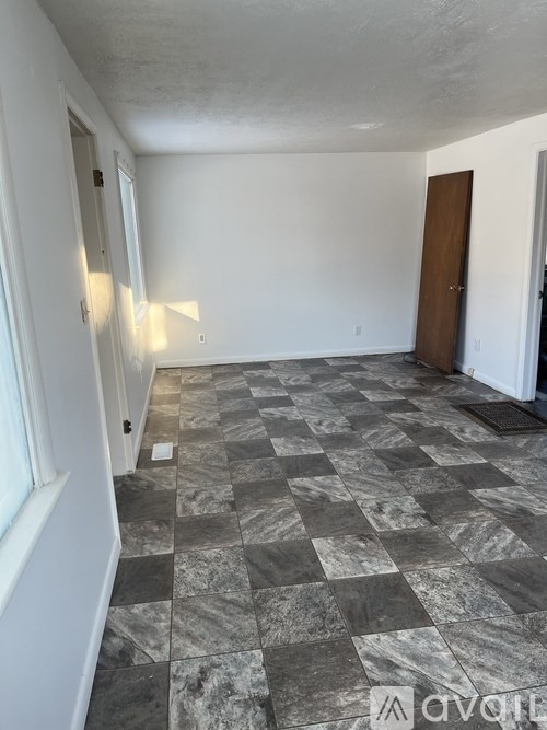 A room with a checkered floor and a door.