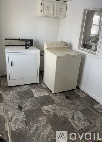 A kitchen with a white fridge and a white cabinet.