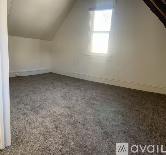 A room with a carpeted floor and a window.