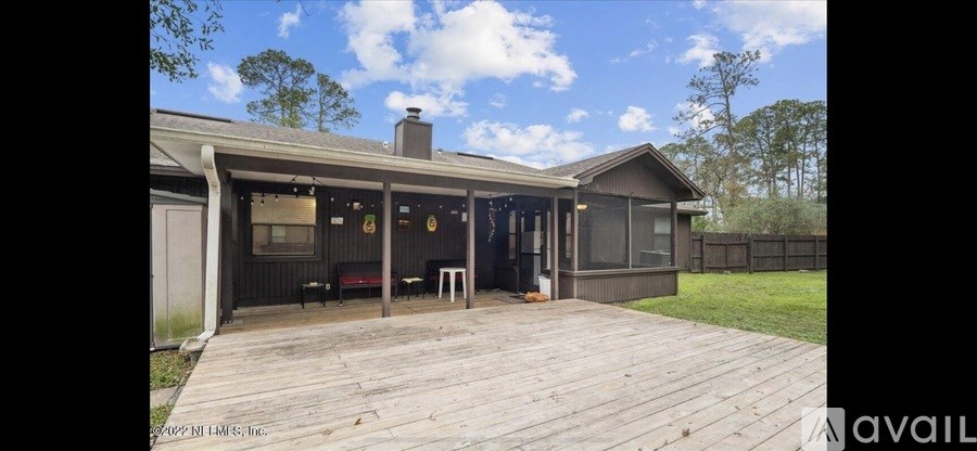 A wooden deck with a black house in the background.