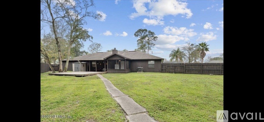 A house with a fence and a grassy yard is for sale.
