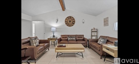 A living room with brown leather couches and a wooden coffee table.