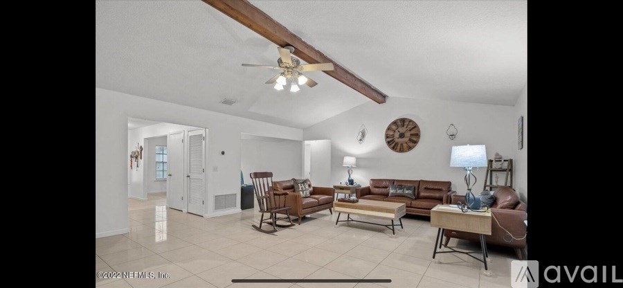 A living room with a brown sofa and a wooden table.