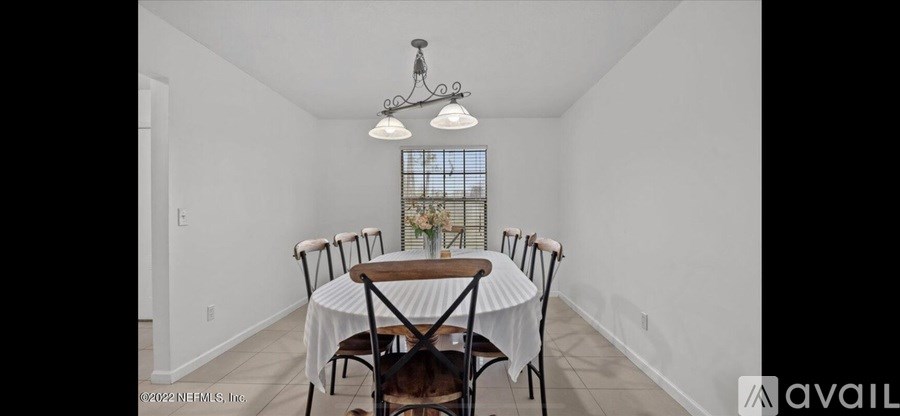 A dining room with a table and chairs.