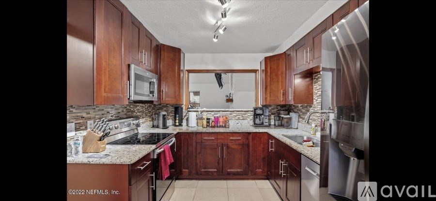 A kitchen with wooden cabinets and granite countertops.