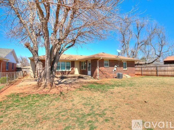 A house with a brown roof and a tree in the front yard.