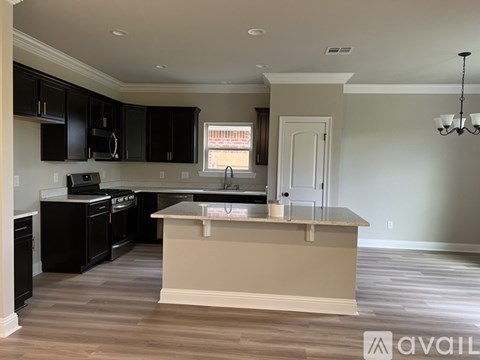 A kitchen with black cabinets and a beige island.