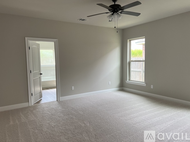 A room with a ceiling fan and a window.