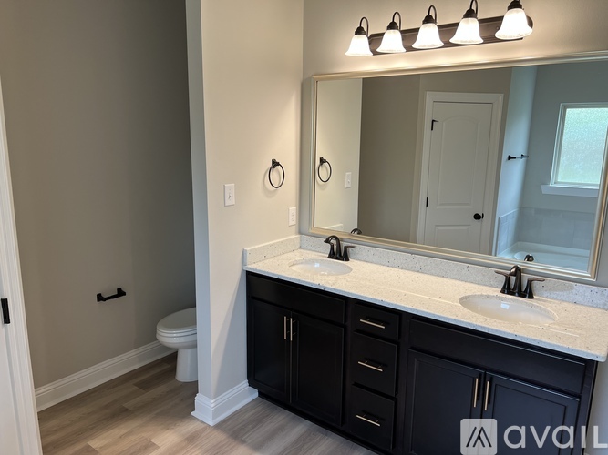 A bathroom with a white countertop and black cabinets.