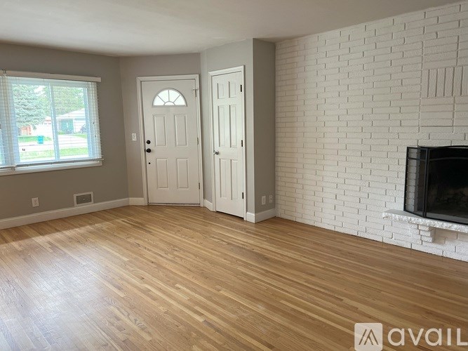 A room with a white brick wall and a wooden floor.