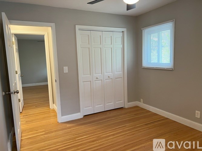 A room with a white door and a window with blinds.