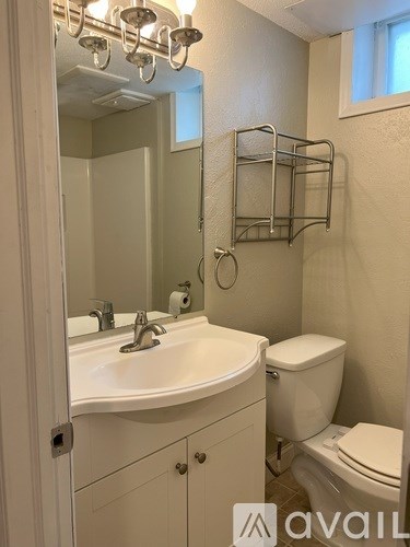 A bathroom with a toilet, sink, and towel rack.