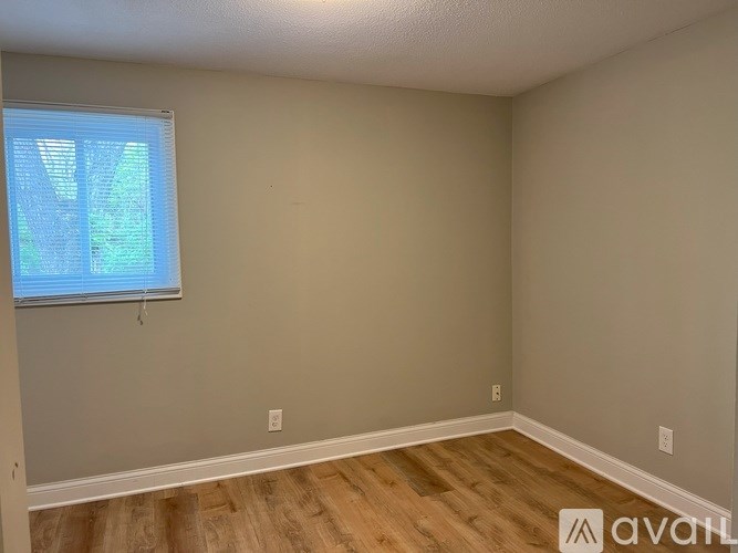 A room with a window and wooden flooring.