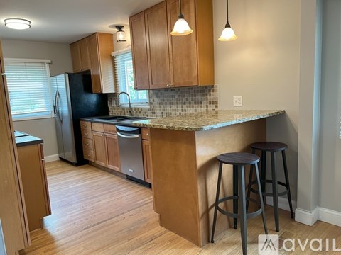 A kitchen with wooden cabinets and a granite countertop.
