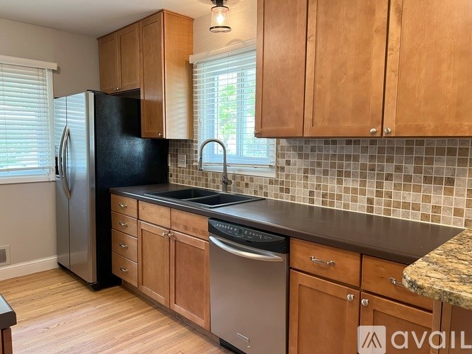 A kitchen with wooden cabinets and a black refrigerator.
