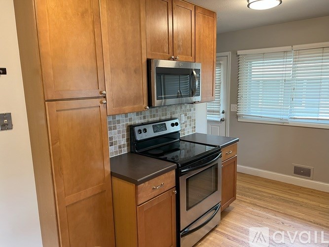 A kitchen with wooden cabinets and black appliances.