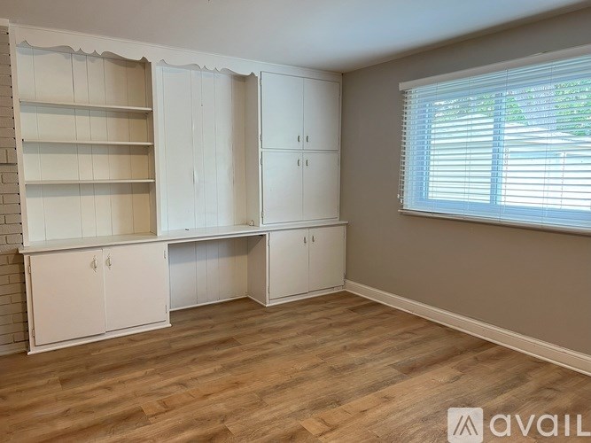 A room with white cabinets and a brick wall.