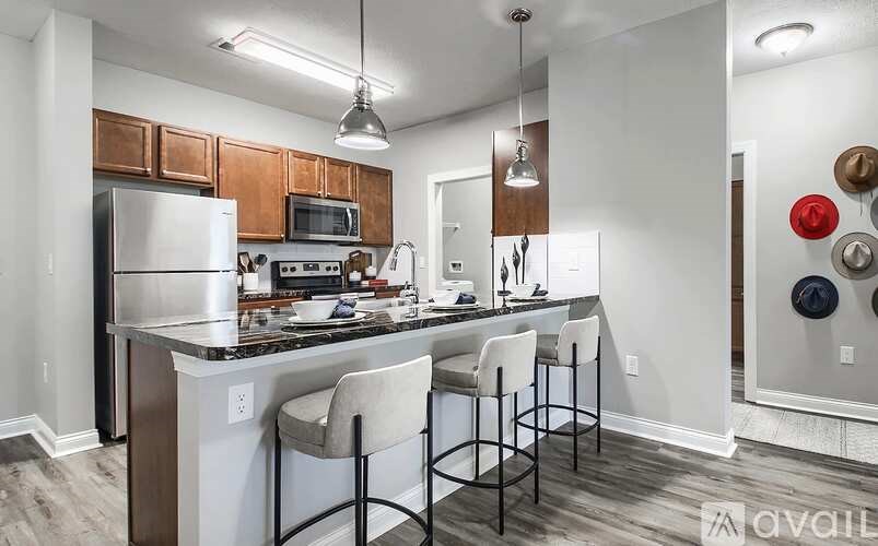 A kitchen with a white counter top and a black bar stool.