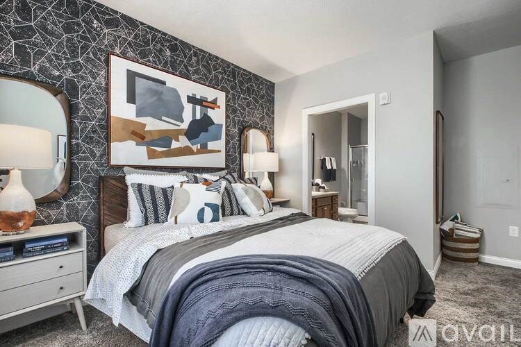 A bedroom with a large bed and a painting on the wall.