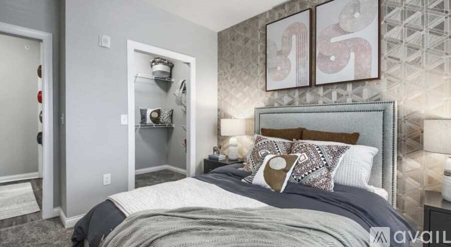 A bedroom with a large bed and a wall-mounted shelf with decorative items.