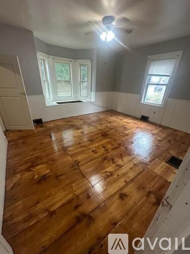 A room with wooden flooring and a ceiling fan.
