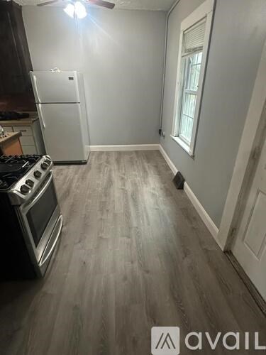 A kitchen with a stove top oven and a fridge.