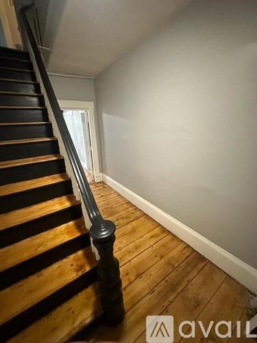 A wooden staircase with a metal handrail.