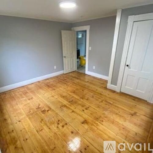 A room with wooden flooring and white doors.
