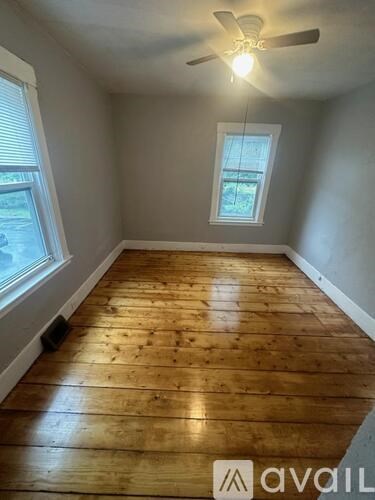 A room with wooden flooring and a window.