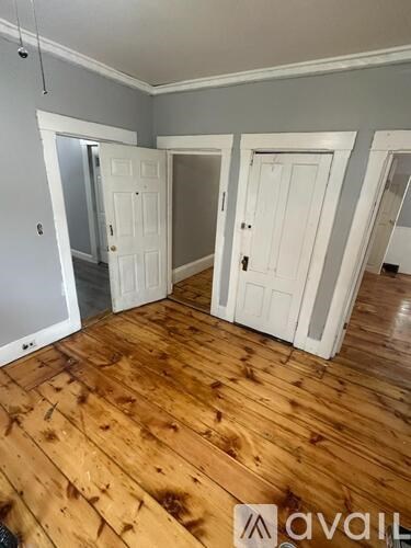 A room with wooden floors and white doors.