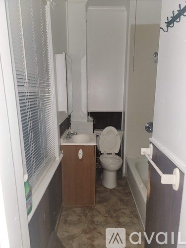 A bathroom with a toilet, sink, and bathtub.