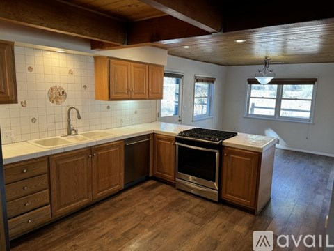 A kitchen with wooden cabinets and a stainless steel stove.