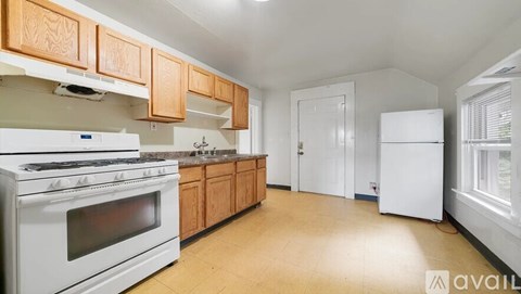 A kitchen with white appliances and wooden cabinets.